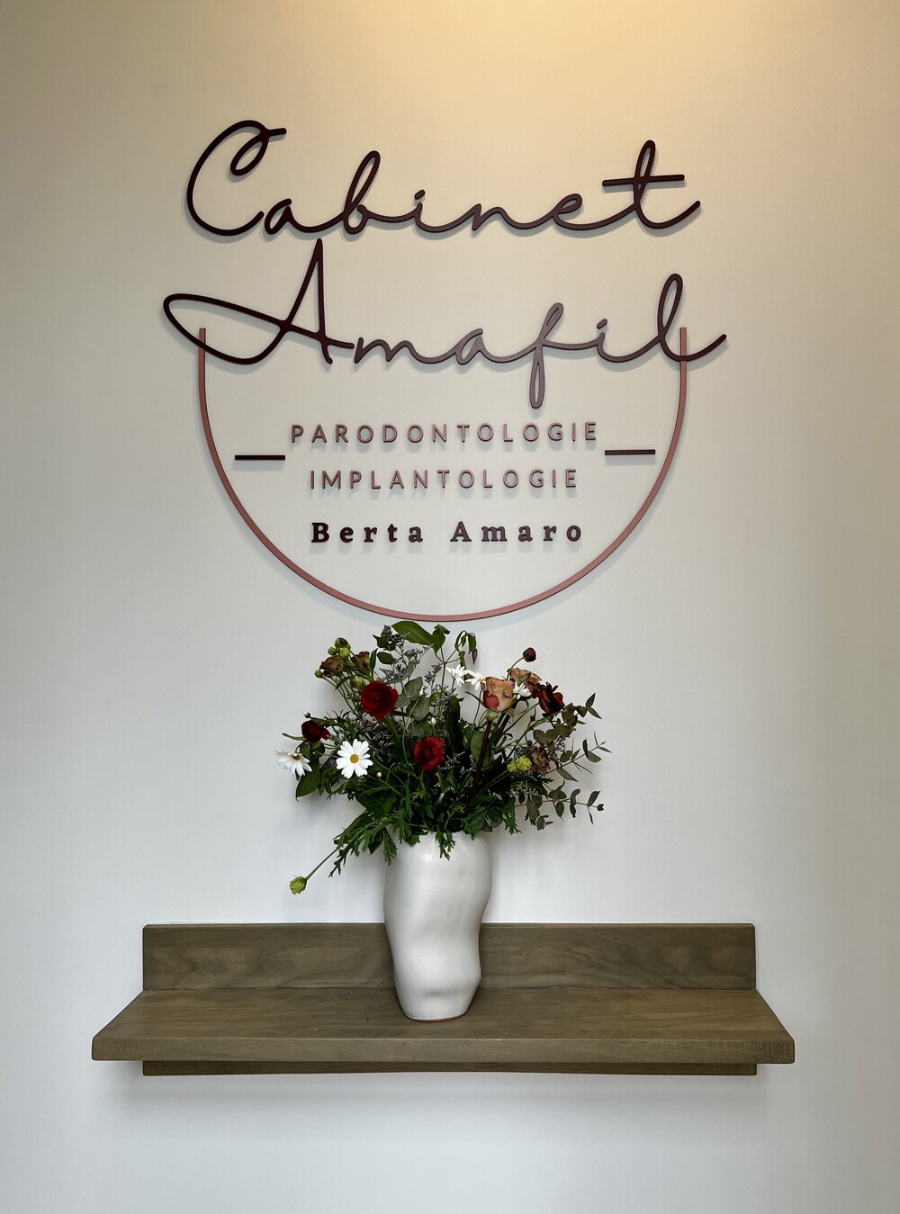 Enseigne du Cabinet Amafil à l'entrée de la clinique, avec un bouquet de fleurs
